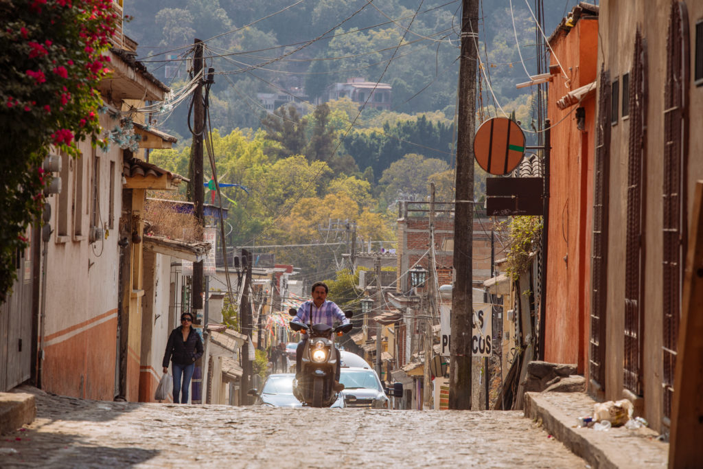 Rollerfahrer und hügelige Straße in Tepoztlán