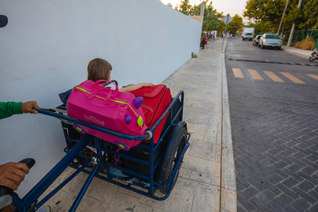Kind auf Koffern auf Lastenrad auf Isla Mujeres