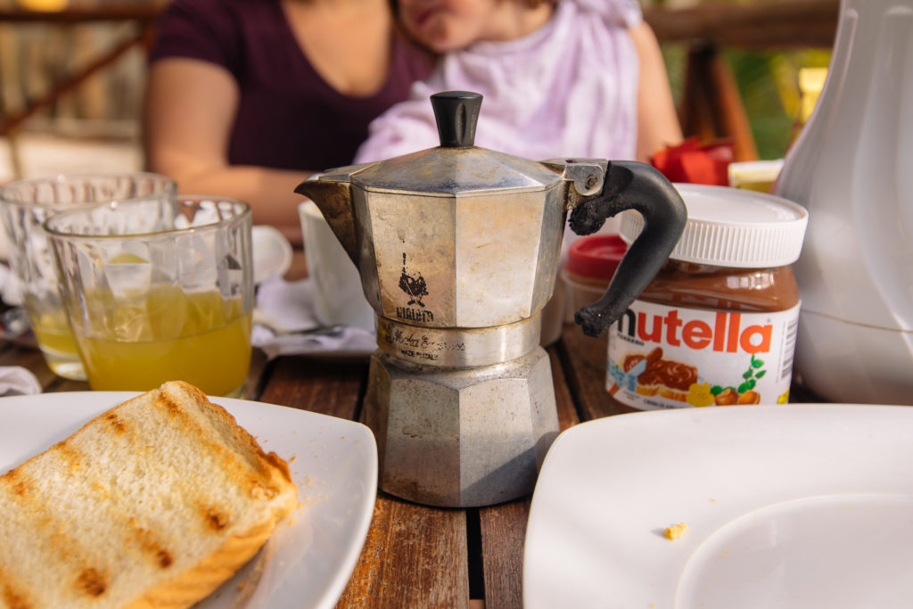 Toast, Saft, Espressokanne, Nutella auf dem Frühstückstisch