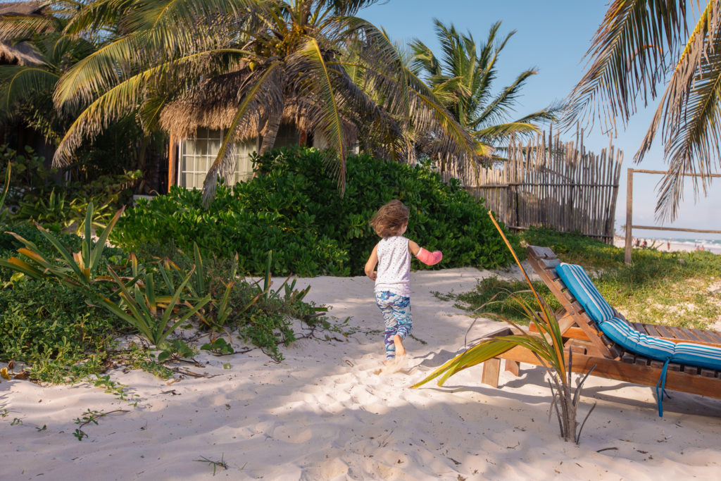Tochter rennt mit dem Gips vom Strand zwischen die Palmen