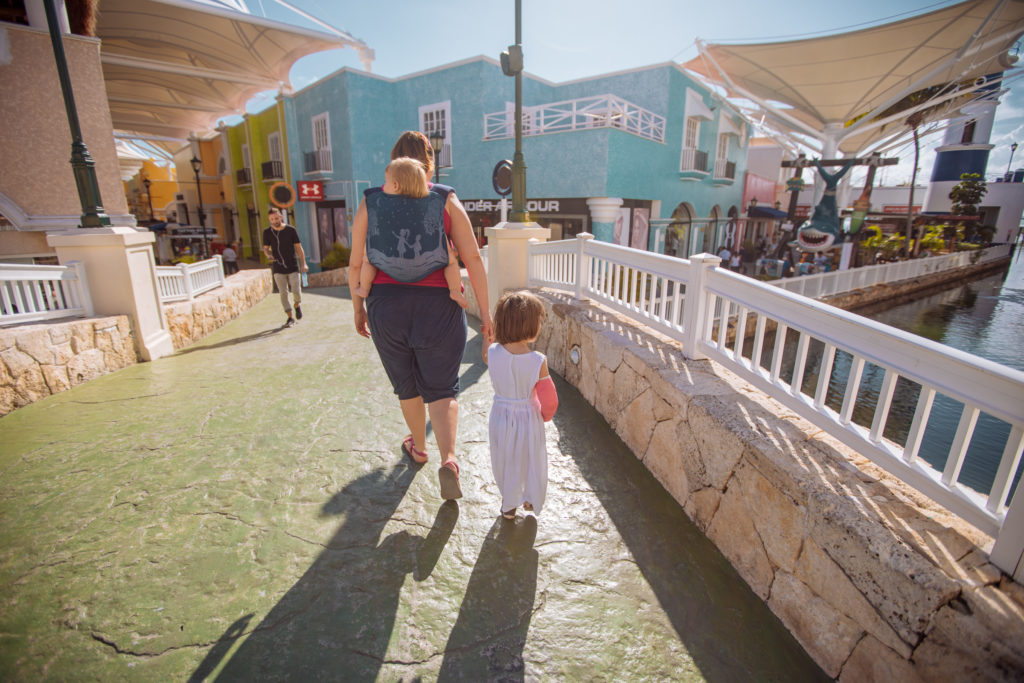 Frau und Kinder betreten Shoppingcenter La Isla in Cancun