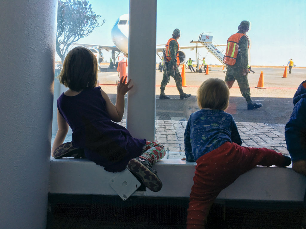 Kinder gucken den Volarisflieger an am Flughafen Puebla