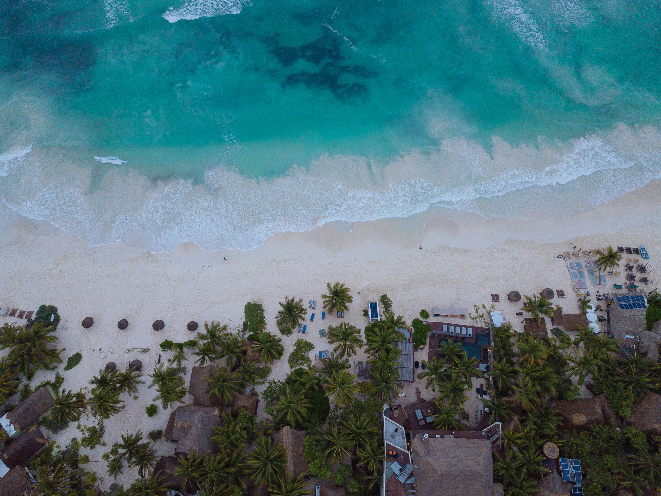 Blick von über der Playa Xcanan auf Meer, Strand und Palmen